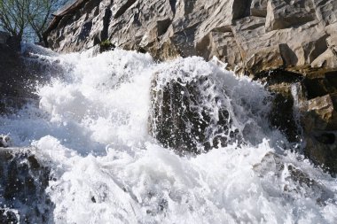 Nehir taşların ve kayaların arasından akıyor. Yaklaş.