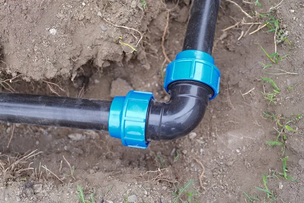 屋外のダートトレンチで曲げ肘継手とPvcパイプのクローズアップ 排水設置配管 地下灌漑システムの概念 — ストック写真
