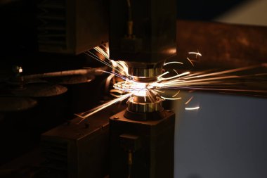 Metal kesme işlemine yakın çekim ve neon kıvılcımlar uçuşuyor. Lazer kesme makinesi ve metal levha. Üretim ve üretim kavramı