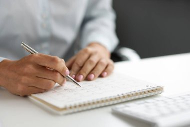 İş planlama ve iş kadını çalışma ve iş takvimlerini kontrol ediyor. Toplantı konsepti için planlama zamanına not alıyorum