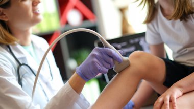 Ortopedik doktor dizinde ultrason olan hasta bir çocuk. İskelet sistemi hastalıkları, çocuk konseptinde eklem hastalıkları
