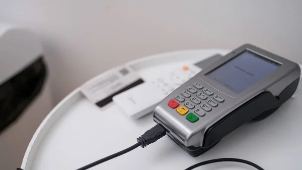 Close-up of terminal for contactless payment, pos device for payment with wire. Online payments, e-payments for services and goods concept