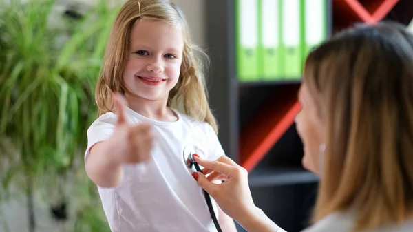 一个快乐的微笑的女孩在儿科医生的预约中的画像 小孩露出大拇指向上的姿势 儿科和医学概念 — 图库照片