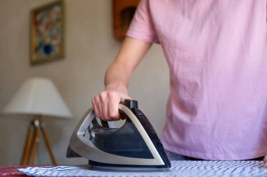 Özel panodaki çarşafları ütüleyen kadının yakın çekimi. Ev işi yapan bir kadın. Oda servisi ve ev işleri konsepti