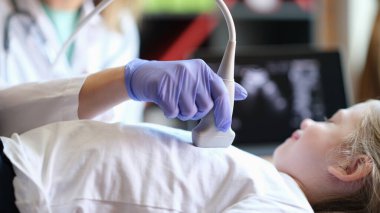 Pratisyen hekimin ultrason cihazı kullanarak çocuğunun kalbinin teşhis muayenesi yaptığı yakın plan. Karın boşluğu işleminin ultrason tarayıcısı