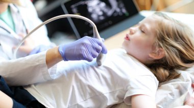 Close-up of female doctor making diagnostic examination of internal organs in children using ultrasound machine. Ultrasound scanner of abdominal cavity procedure