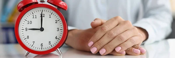 Alarm clock on desk with businesswoman or time concept early morning or late evening. Time management and deadline concept