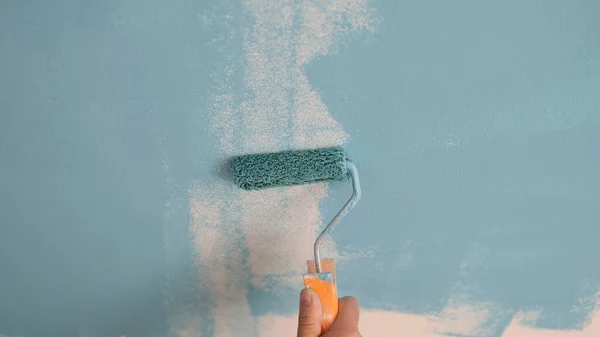 Hand painting the wall with decorator roller and painting walls. Master painter services