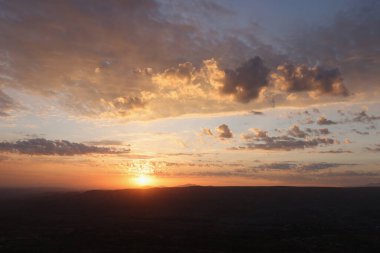 Düzlüklerin ve dağların ardından gelen son güneş ışınları. Güzel gün batımı ya da gün doğumu