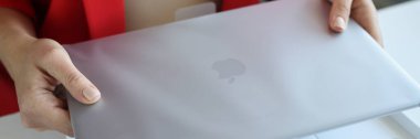 Minsk, Belarus - 7 Nisan 2022: Kadın paket konseptinde Apple Macbook Pro dizüstü bilgisayarı tutuyor