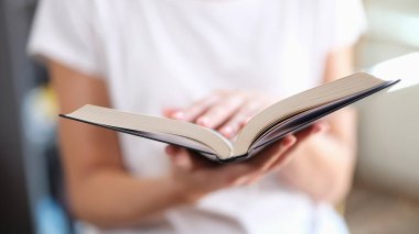 Kitapçıda açık kağıt kitap okuyan kadın çok satan kitap konsepti. Okumak ve eğlenmek hobi modern edebiyat evde yakın çekim