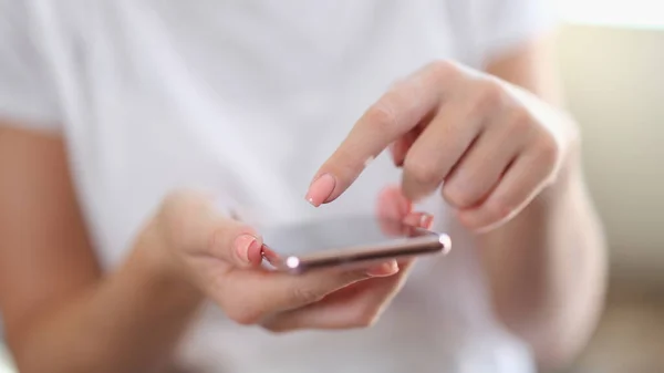 Woman hands touch screen of smartphone closeup. Mobile apps and chatting