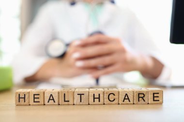 Doktor steteskop bilgisini sağlık ve tıbbi bakım metniyle tutuyor. Sağlık sigortası ve hizmet