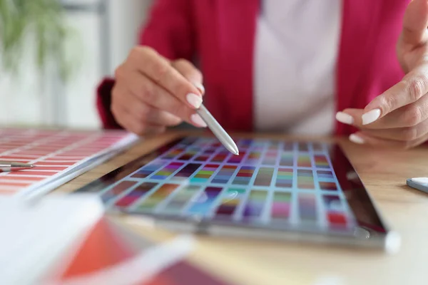 Woman working with color swatches for selection on tablet. Applications for color palettes