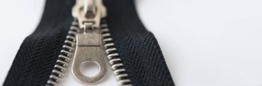 Açık siyah pirinç fermuarın yakın çekim makro çekimi beyaz arka planda izole edildi. Metal fermuar fermuara bağlıdır ve fermuar konsepti kaydırıcısı tarafından çekilir
