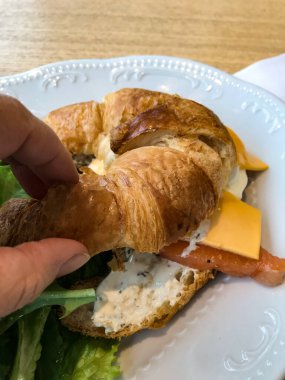 Avokado, tereyağı, zeytin, şifalı otlar ve somon balıklı sandviç.