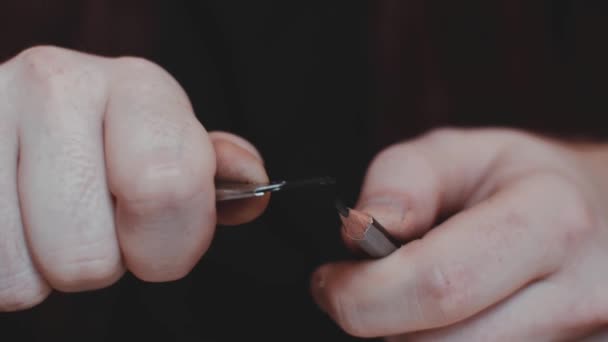 Fermer les mains filmées d'un homme qui aiguise le crayon méditatif à l'aide d'un couteau utilitaire — Video
