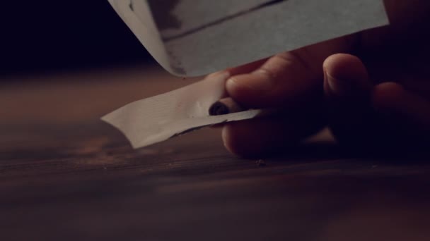 Падение раздавленной марихуаны падает на салфетку с фильтром, чтобы сделать сустав — стоковое видео