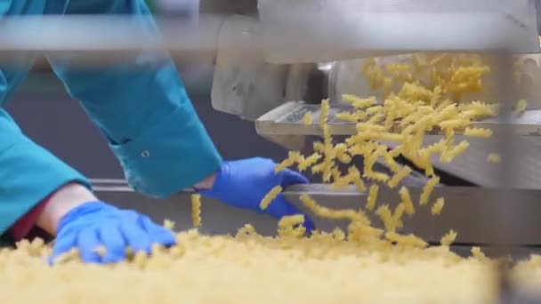 Při pohledu na dělnické ruce v modrých rukavicích, které řídí kvalitu těstovin — Stock video