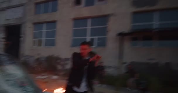 Ung aggressiv protesterare krossar vindrutan på en bil med armeringsjärn i ghetto — Stockvideo