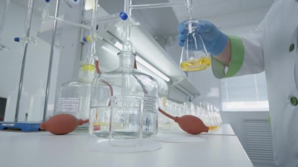 Scientist Chemist Mixing In Laboratory Yellow Liquid (en inglés). Investigador de laboratorio — Vídeos de Stock