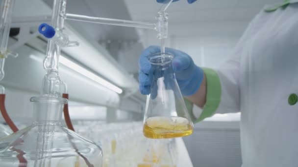 Scientist Chemist Mixing In Laboratory Yellow Liquid (en inglés). De cerca. — Vídeos de Stock