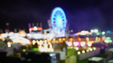 Gece lunaparktaki dönme dolabın görüntüsü bulanık..
