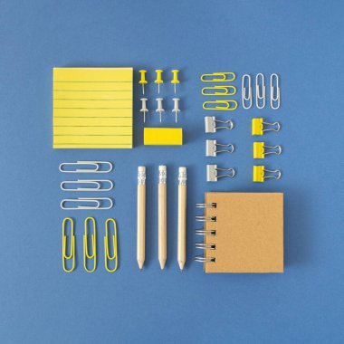 Eylül, okula dönüş, ofis konsepti. Çeşitli okul / ofis malzemeleri. Kare düzenleme kalemleri, kasetler, silgiler, raptiyeler, cetveller, keçeli kalemler, ataçlar, post-tit notlar, notlar. Parlak mavi arkaplan.