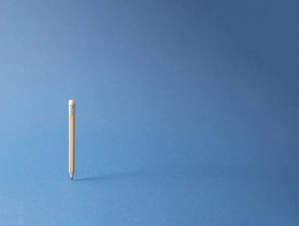 木製の鉛筆を持ち上げます 創造的なオフィス ビジネスコンセプトを最小限に抑えます 青の背景 — ストック写真