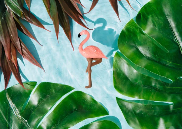 夏天和放松的概念 粉色的火烈鸟在清澈明亮的蓝色波浪形水面上 带着热带的叶子 放松和快乐的概念 — 图库照片