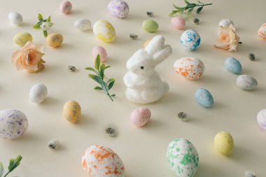 2022 Paskalya ve bahar konsepti. Pastel Paskalya konsepti pastel Paskalya yumurtaları, bahar çiçekleri ve beyaz Paskalya tavşanı. Paskalya pastel arka planı. Yaratıcı Paskalya Düzenlemesi.