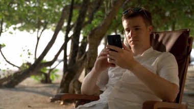 The man received bad news on the phone while on vacation. Spoiled mood on vacation