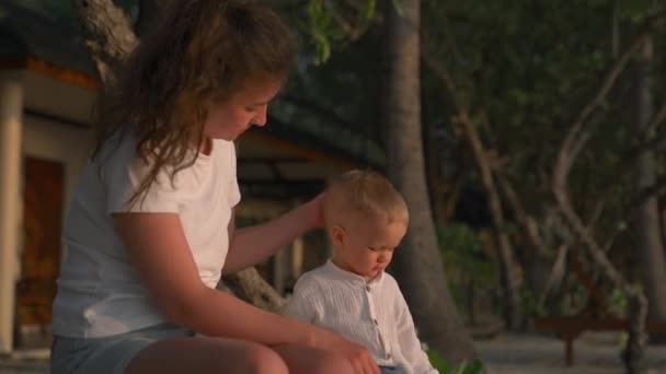 Caucasian Woman Pats Her Child Head While Sitting Beach Sun — Stock Video