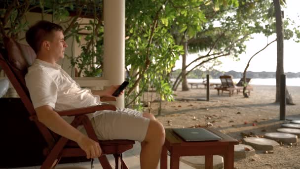Man Scrolling News Smartphone Beach Chair Caucasian Male Puts Sunglasses — Stockvideo