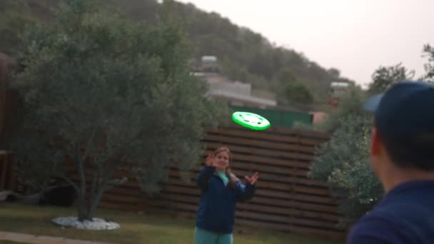 Woman Catches Green Flying Frisbee Thrown Man Brown Fence Countryside — Vídeos de Stock