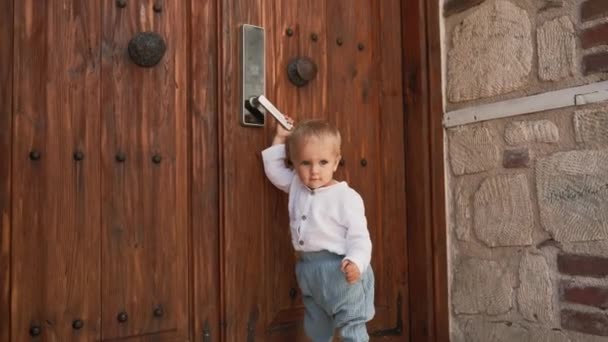Curious Toddler Stands Big Wooden Door Moving Handle Blond Boy — Video Stock