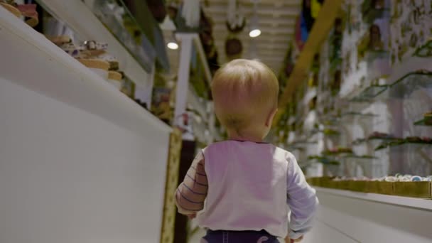 Blond Toddler Walks Aisle Big Shop Looking Souvenirs Buy Trip — Stock Video