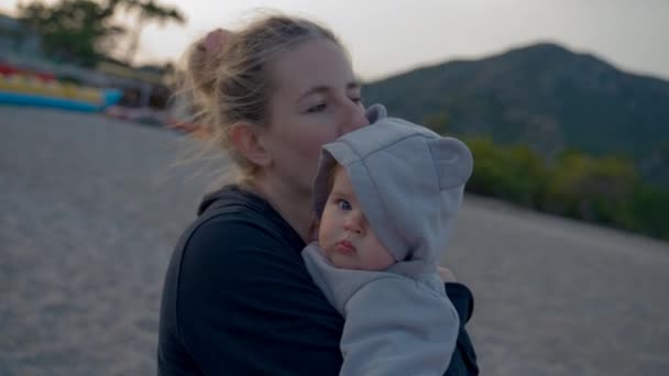 Mother Holds Cute Little Baby Arms Standing Beach Dark Mountains — Stock video