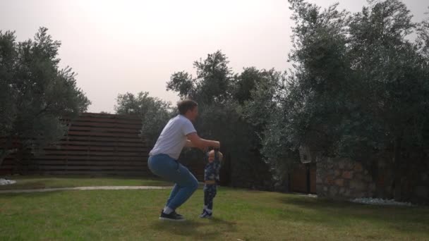 Happy Man Throws Catches Little Boy Backyard Lush Green Trees — Vídeos de Stock