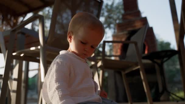 Blond Toddler Sits Wooden Chairs Yard Country House Silhouette Focused — 图库视频影像