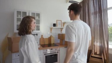 Mutlu çift mutfak tezgahına gelip kameradaki yeni dairenin anahtarını gösteriyor. Erkek ve kadın, üçüncü şahıstan POV 'a başarılı bir alım ile mutlu oluyorlar.