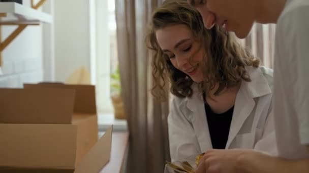 Άντρας Και Γυναίκα Κρατούν Χρυσά Κουτάλια Βγαλμένα Από Χάρτινα Κουτιά — Αρχείο Βίντεο