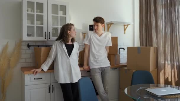 Молодой Человек Женщина Разговаривают Кухне Опираясь Столешницу Распакованными Бумажными Коробками — стоковое видео