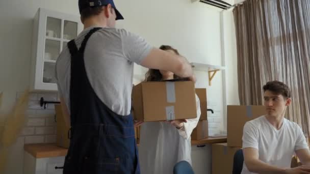 쿠리어는 부부가 아파트에 상자를 가지고 옵니다 남자가 식탁에 주방에서 일하는 — 비디오