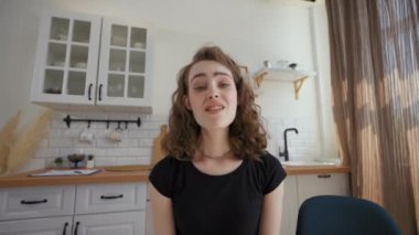 Woman waves hello to camera talking to friends on video call. Lady distracts on hugging elderly father coming into kitchen closeup from POV to third party