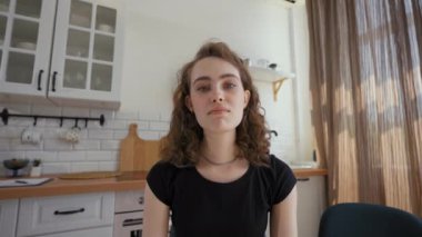 Cheerful woman talks to relative on video call distracted by boyfriend. Man comes into kitchen to hug girlfriend closeup from POV to third party