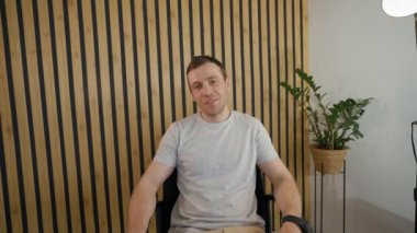 POV of young employee talking to friend on video call getting interrupted by call from boss. Man gets up from chair walking out of office room