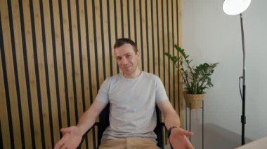 Businessman talks to friend on video call getting interrupted by mom coming to office. Man distracts from communication to hug mother from POV to third party