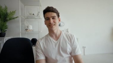 Man talks to girlfriend on video call distracting on father coming into room. Guy talks in camera turning to dad to shake hands from POV to third party