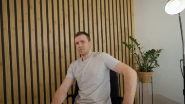 POV of young man refusing to look in camera and covering eyes with hand. Shocked employee sits at desk in office talking with friend via video call